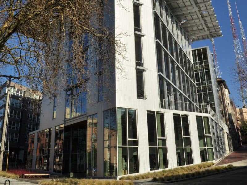 The Bullit building in Seattle, Washington, USA. It has a white rendered exterior with many windows and a large, overhanging roof.