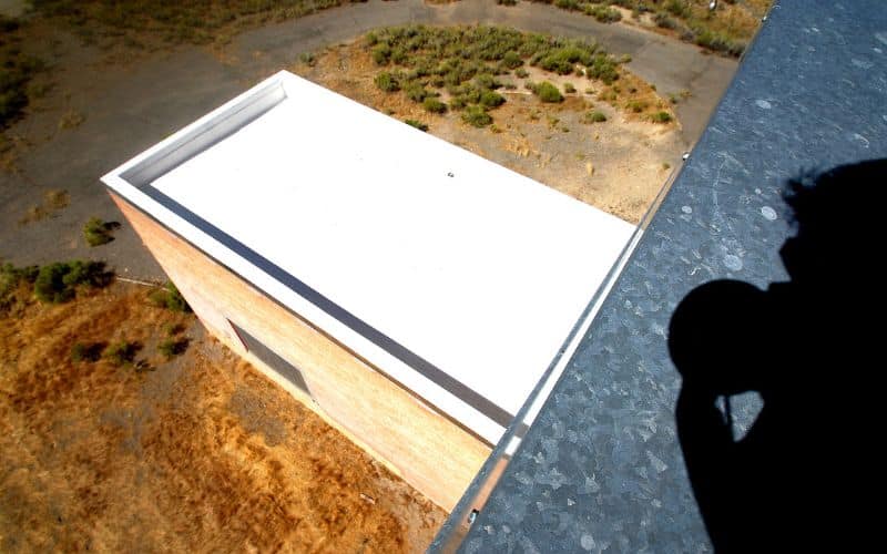 A cool roof installed on an extension to an existing building. The roof is flat and white in color.