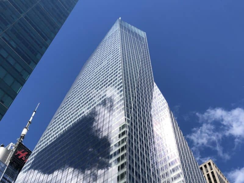 An image of One Bryant Park Bank of America Tower in NYC, USA. This is a high-rise building that has fully glazed walls reaching to the sky above, which is pure blue.