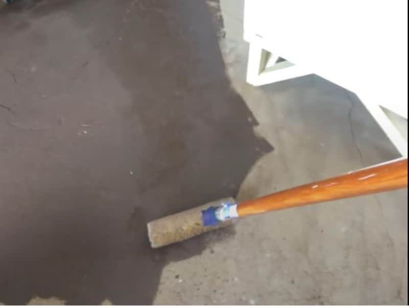 A roller being used to apply linseed oil to an earthen floor.