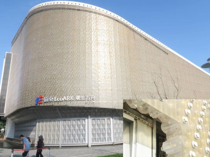 A photograph of the EcoArk Pavillion in Taiwan. The building is made from light gray plastic and has smooth, swooping curves. There is an inset picture in the bottom right of the image showing closeup detail of the recycled plastic construction.