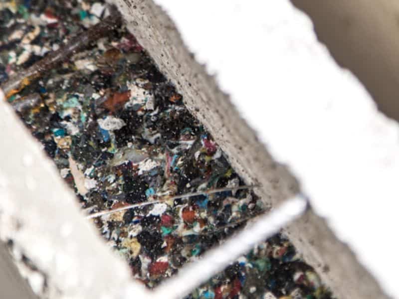 A cross-section of an Ecodom thermal wall made with a recycled plastic core. The wall has a solid mass of thermally-efficient recycled plastic sandwiched between two layers of concrete held together with rebar.