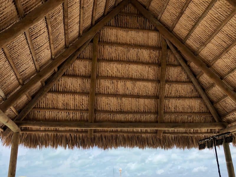 A pitched bamboo roof with a thatched roof. The  structure doesn't have walls.