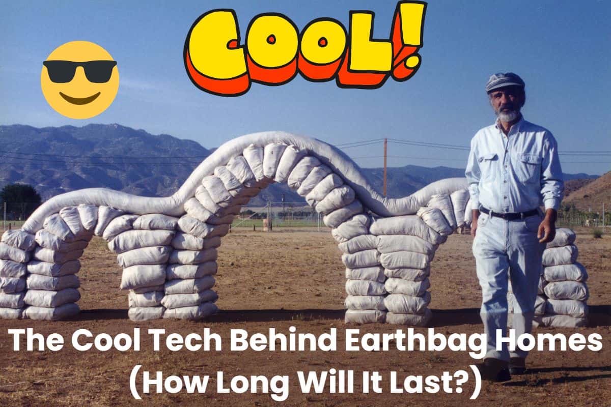 A photograph of renowned earthbag architect and advocate, Nader Khalili, in front of an earthbag wall with archways. There is a cartoon sun wearing sunglasses and the word "Cool!" written in bubble writing above it. The ground upon which the earthbag structure is built is on a plain and has bare soil with mountains in the far background. Across the bottom of the image are the words "The Cool Tech Behind Earthbag Homes (How Long Will It Last)?"