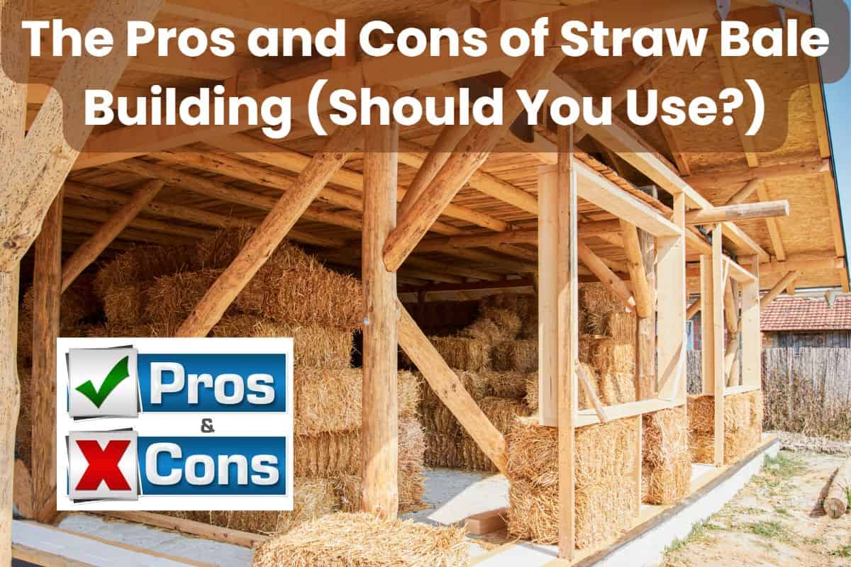 A partly-built straw bale house. There are straw bales stacked inside the post-and-beam structure and the roof is installed but the walls are not yet filled with straw bales. The words "The Pros and Cons of Straw Bale Building (Should You Use?)" are written across the top and there is a box in the bottom left of the image with a green tick and red cross and the words "pros" and "cons" next to them.