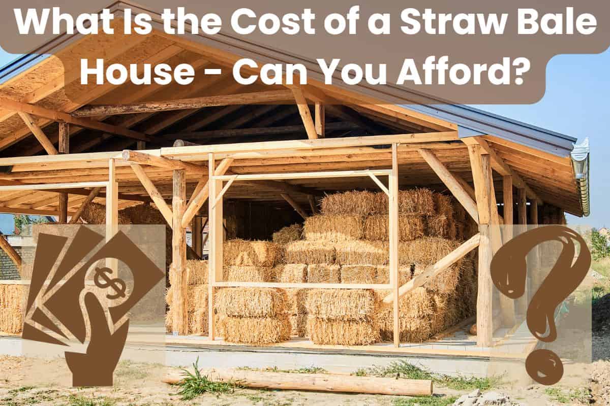 A photograph of a straw bale house being built. The structure is post-and-beam with straw bales filling in the walls between the frame members. There are lots of straw bales stack up inside the house under cover to keep them dry. The words "What Is the Cost of a Straw Bale House - Can You Afford?" are written across the top in white letters on a light brown, partially transparent background. There is a money icon in the bottom left corner and a question mark in the bottom right corner, both in brown.