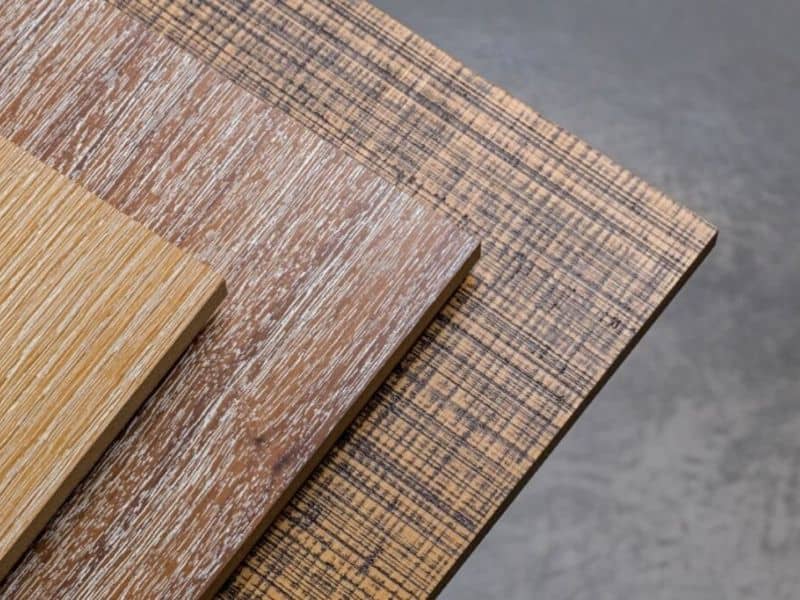 Various types of hardwood and bamboo plywood sheets stacked on top of each other.