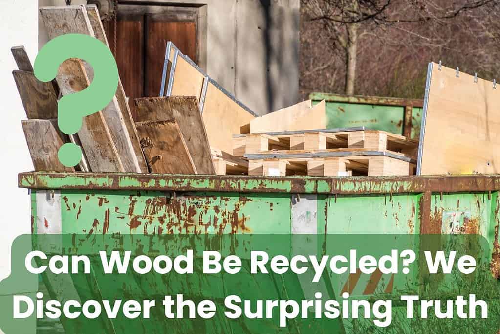 Green waste skip full of waste wood. The skip is quite rusty, and the wood it contains ranges from pallets to wooden planks and panels.