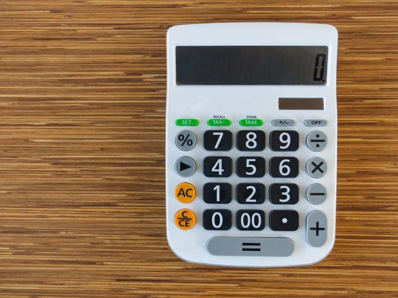 A pocket calculator on a wood surface.