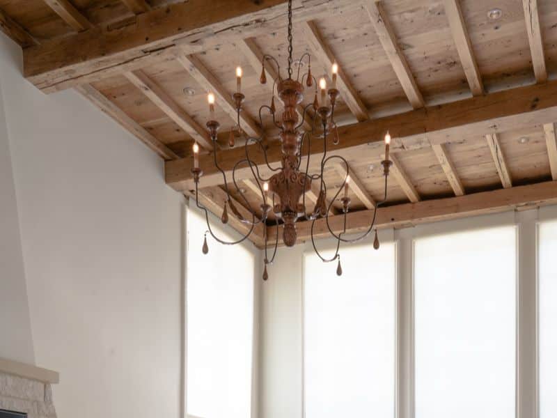 A reclaimed white oak ceiling with an iron candelabra hanging from it.