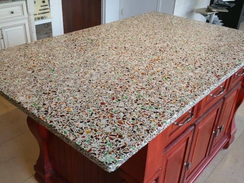 A recycled glass countertop on the island in a kitchen.