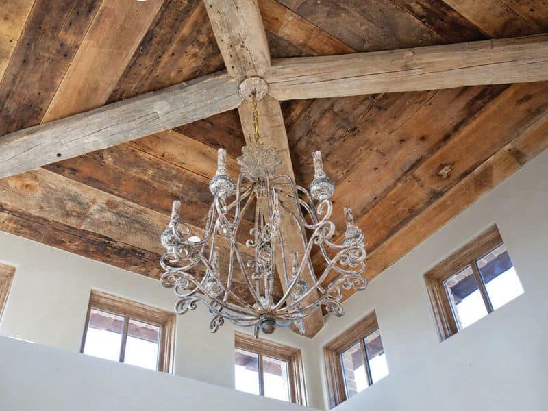 A reclaimed wood ceiling was installed by The Vintage Wood Floor Company. It has old beams and panels that add tremendous character to the room. A metal candelabra hangs from the center of the ceiling.