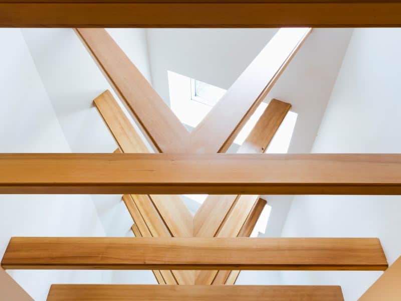 A vaulted wood ceiling made from reclaimed wood. The walls are plain white, and there is a roof light window.