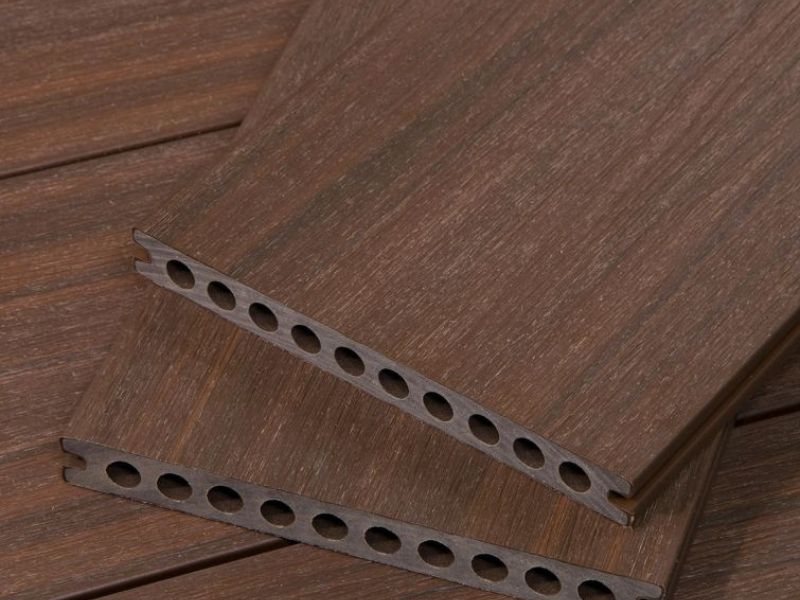 A closeup of Cali Bamboo's dark brown composite decking boards. The holes along the end are clearly visible, as is the grain pattern on the top surface.