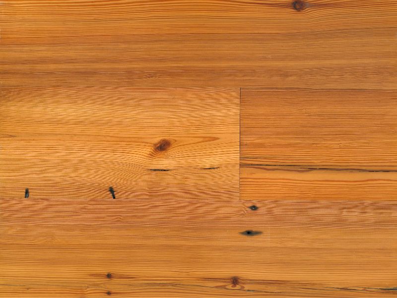 A photograph of a close-up heart pine countertop. It is mid-brown and has a tightly-packed grain pattern.