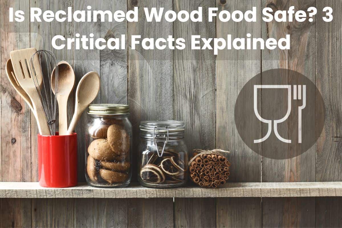 Kitchen utensils and jars of food sit on a reclaimed wood shelf with a reclaimed wood accent wall behind. Across the top of the photograph are the words, "Is Reclaimed Wood Food Safe? 3 Critical Facts Explained." on the right-hand side is a "food safe" icon, showing a wine glass and a fork in a circle.