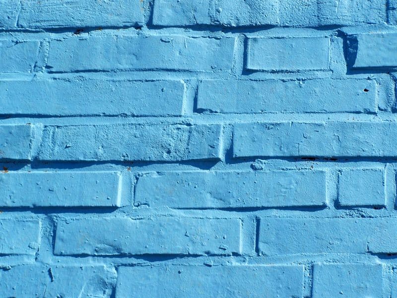 An adobe brick wall that has been painted blue.