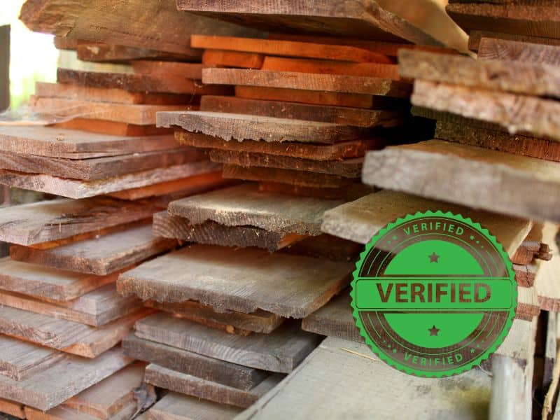 Stacks of reclaimed wood planks with a green "verified" badge in the bottom right corner.