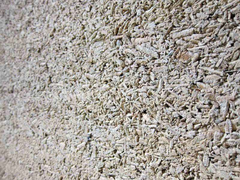 A closeup photograph of a hempcrete block. The individual hurds of the hemp plant can easily be seen in the surface of the block.