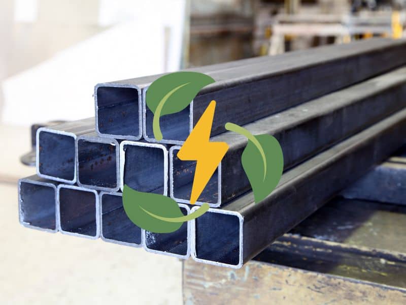 A stack of square-sectioned recycled steel tubes. In the center of the image is a yellow cartoon electrical symbol surrounded by green cartoon leaves arranged in a circle.