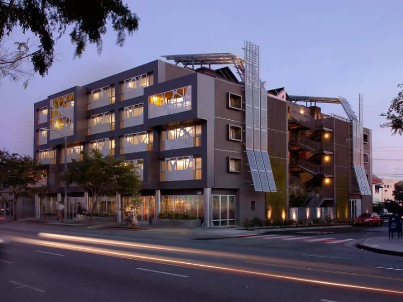 A photograph of the Sierra Bonita Affordable Housing project. It has five floors and is located on the corner of two streets.