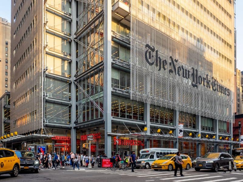 A photograph of the New York Times Building in New York with the NYT logo above its entrance.