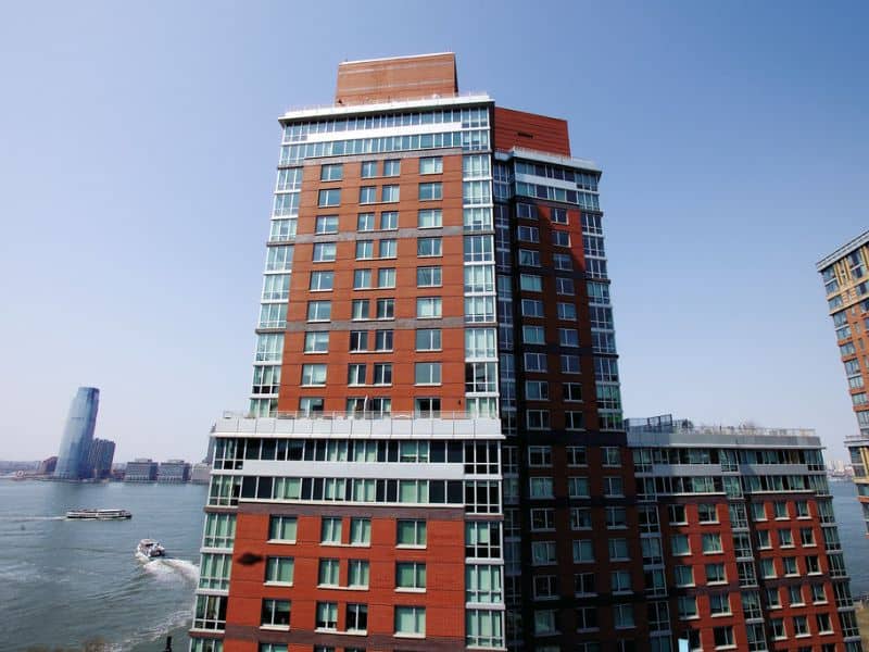 A photograph of the Solaire, a high-rise building with red brick walls and a lot of glass on its façade.