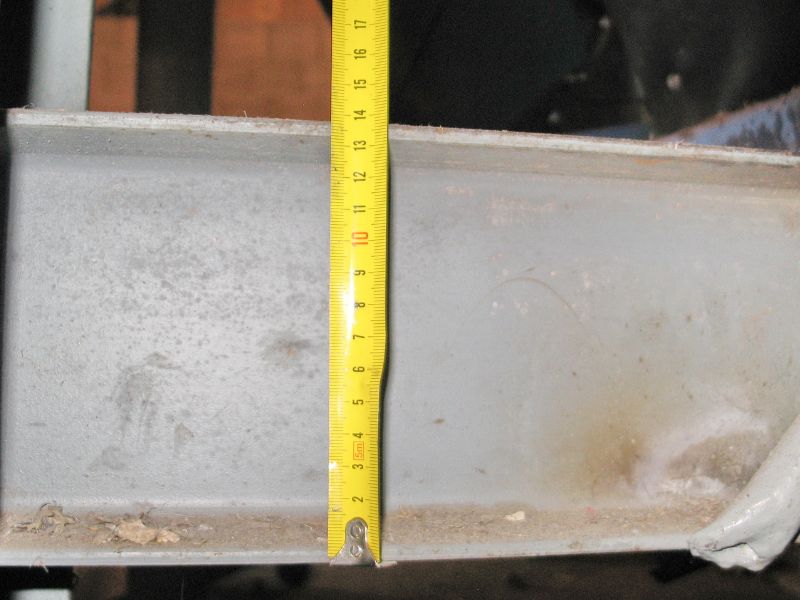 A gray recycled steel beam is measured with a yellow Imperial tape measure.