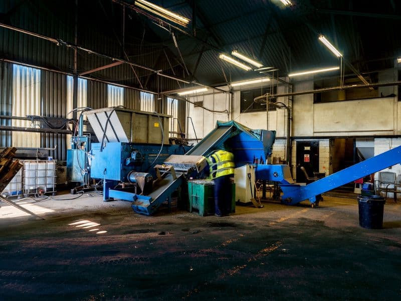 A photograph of the premises of LCM Scrap Company, UK. The image shows a process line where scrap metal is handled.