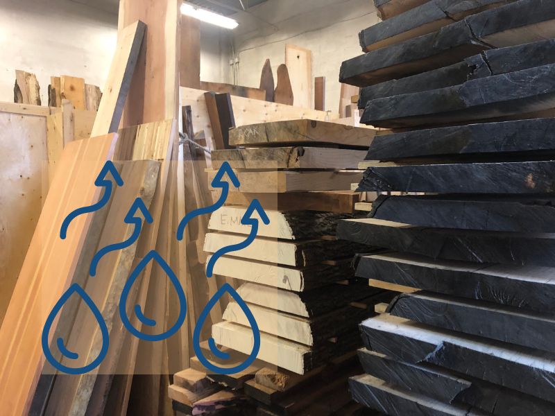 Wooden planks stacked indoors to dry with an overlay of water droplets evaporating.