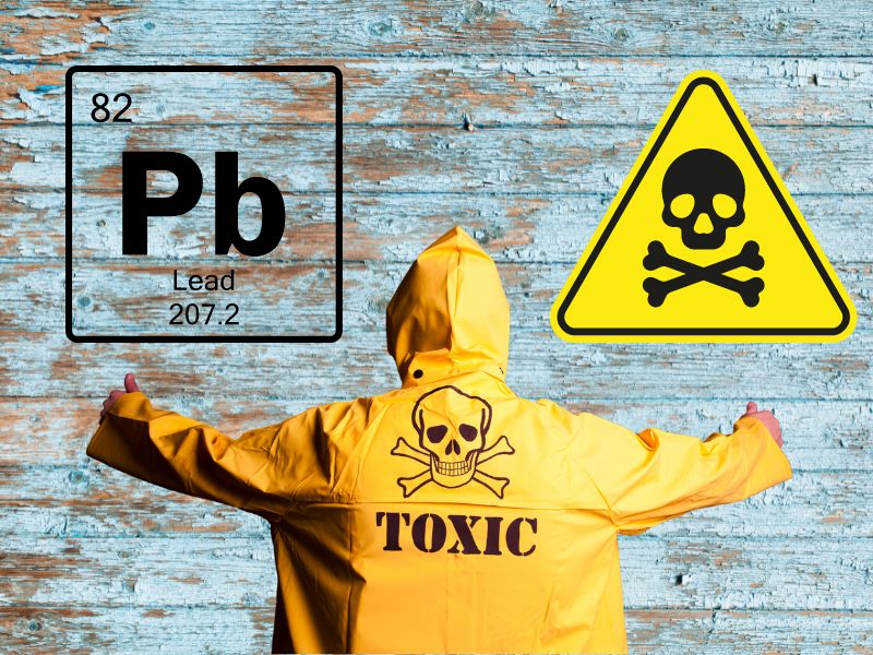 A reclaimed wood wall with flaking lead paint. At the bottom is a person with their back to the camera wearing a yellow waterproof jacket with a black skull and crossbones and the word "Toxic." In the upper right of the image is a yellow triangle warning symbol with a black skull and crossbones. In the upper left of the photograph is the chemical symbol for lead "Pb" along with its entry in the periodic table, including its atomic number (82) and molecular weight (207.2).