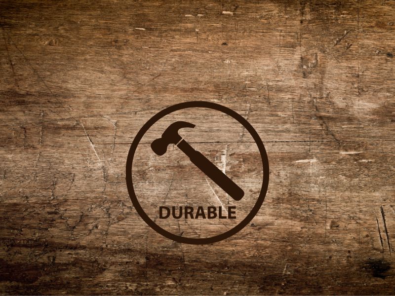 A photograph of a dark brown plank of reclaimed wood with prominent grain pattern and signs of wear and tear. A large hammer logo is superimposed on top of the photo with an enclosing circle and the word "durable".